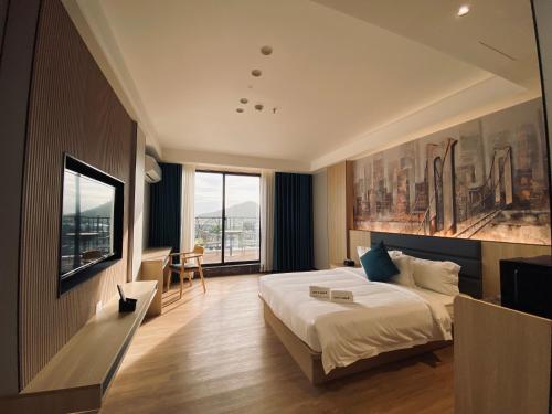 a bedroom with a large bed and a large window at Fan's Hotel Palo in Tacloban