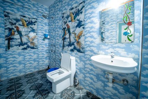a blue bathroom with a toilet and a sink at Marcelo Palace - Baga in Calangute