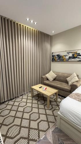 a hotel room with a bed and a couch and a table at شقة حي الوزارات in Riyadh