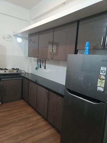 a kitchen with a stainless steel refrigerator and cabinets at Eva homes in Vagamon