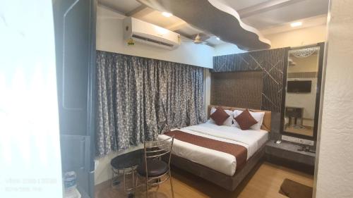 a bedroom with a bed and a chair in it at Hotel Abraj Inn in Mumbai