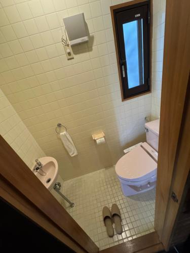 a bathroom with a toilet and a sink at Kitakaze Chalet in Myoko