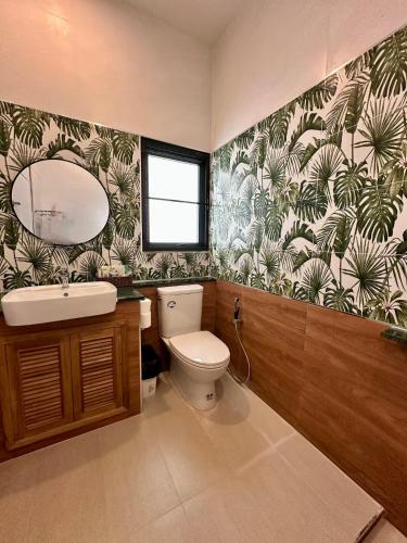 a bathroom with a toilet and a sink and a mirror at Tiger on the Beach in Krabi