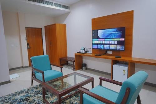 a living room with two chairs and a table and a tv at Sugan Hotel and Resort in Phalodi