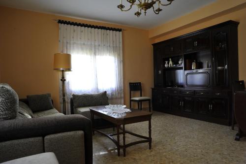 a living room with a couch and a tv at Casa Los Olivos in Grávalos