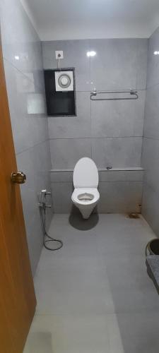 a bathroom with a white toilet in a room at Hotel Avenue Gest House in Dabhoi