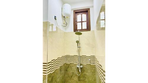 a shower in a bathroom with a window at Victoria Nature Resort in Digana