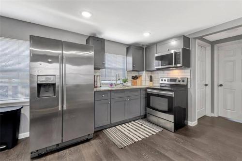 a kitchen with a stainless steel refrigerator and appliances at Super Cozy 2 bedroom with Fast WIFI and Queen Bed close to Downtown Houston!! in Houston
