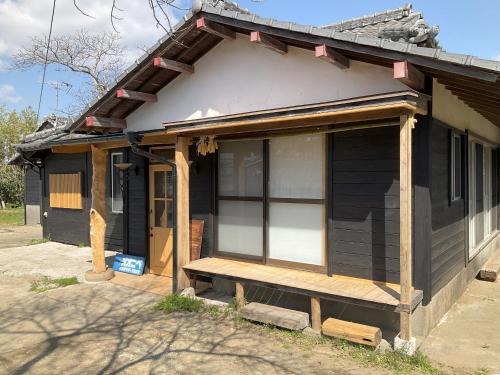 a house with a porch with a bench on it at イシザキサーフハウスオオニベ 一組一棟貸し in Miyazaki