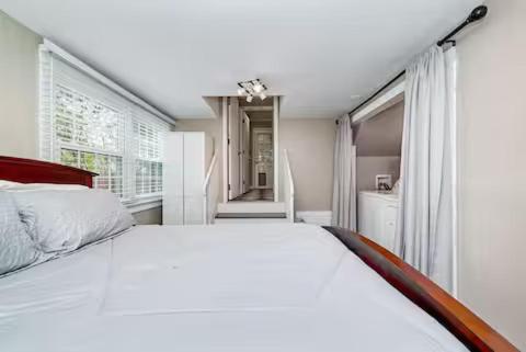 a bedroom with a large white bed and windows at LUXURY HOME 5 BR 3 BA Near Beaches and Venues in Hampton
