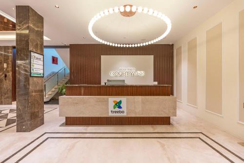 a lobby of a hotel with a reception desk at Treebo Premium Pine Tree Courtyard in Chennai