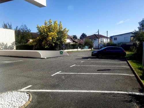 un'auto parcheggiata in un parcheggio con un muro di Atlantic Hôtel a Pau