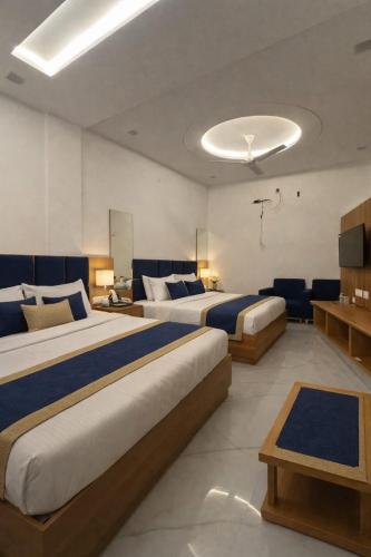a hotel room with two beds and a television at Hotel Golden Palace in Agra