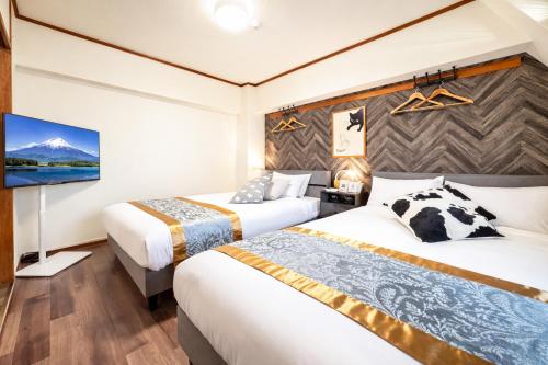 a hotel room with two beds and a flat screen tv at ウィングランデ博多南 in Fukuoka