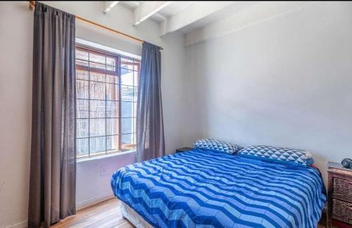 a bedroom with a bed and a large window at 44SeagullMelkbosstrand in Melkbosstrand