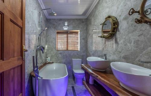 a bathroom with two sinks and a tub and a toilet at 44SeagullMelkbosstrand in Melkbosstrand