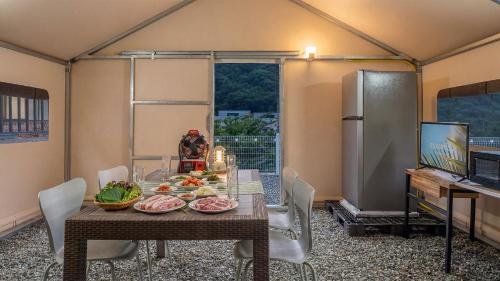 a dining room with a table with food on it at Gapyeong Ddobagi Pet & Spa Glamping in Gapyeong