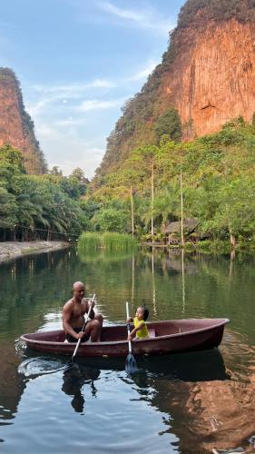 a man and a child in a boat in the water at KRABI BAMBOO KINGDOM at AOLUEK PARADISE in Ao Luk
