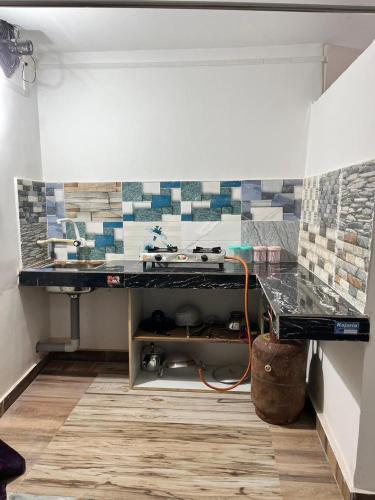 a room with a counter with tiles on the wall at Swagatom Homestay in Jorhat