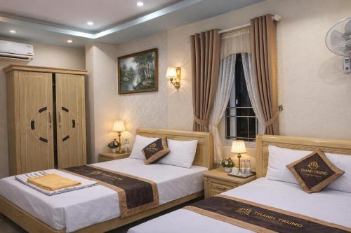 a hotel room with two beds and a window at Thành Trung Motel in Cat Ba