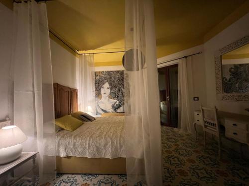 a bedroom with a bed with a painting on the wall at Villa BellaVista in Belvedere Marittimo