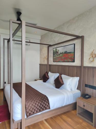 a bedroom with a canopy bed with white pillows at Olga Resorts in Vagamon