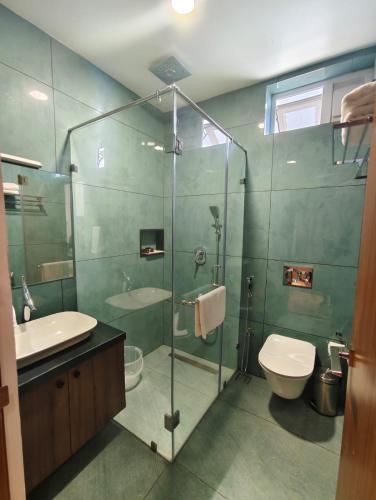 a bathroom with a glass shower and a toilet at Olga Resorts in Vagamon