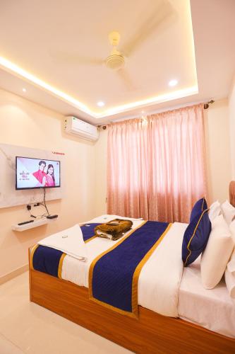 a bedroom with a large bed and a tv at S V Grand Inn in Bangalore