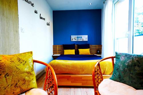 una camera da letto con un letto giallo e due sedie di Cosy Gare a Caen