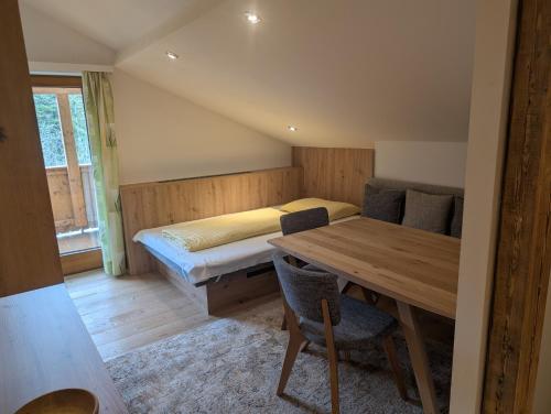 a bedroom with a bed and a table and chairs at Haus Luzia in Reith im Alpbachtal