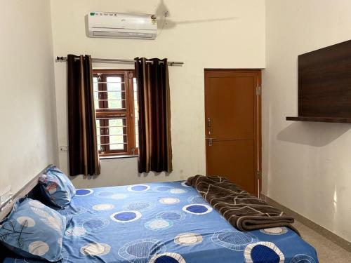 a bedroom with a bed in a room with a window at Hotel Vishal in Jaipur