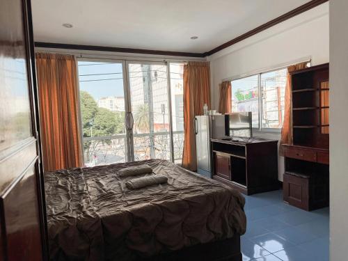 a bedroom with a bed and a large window at Green Hotel in Pattaya South