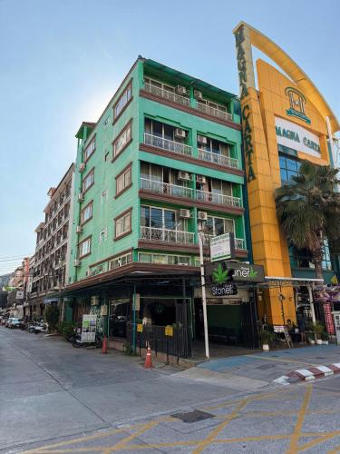 a tall green building on a city street at Green Hotel in Pattaya South