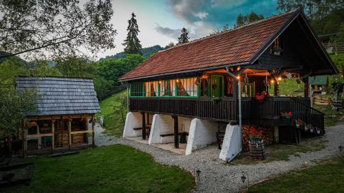 a large house with a green door and a building at La Răscoala in Petrila