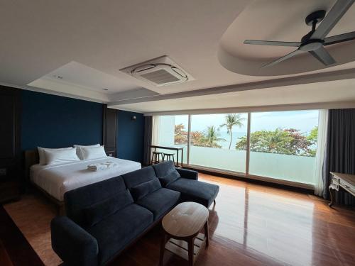 a hotel room with a bed and a couch at Gooseberry Baan & Bistro in Pattaya South