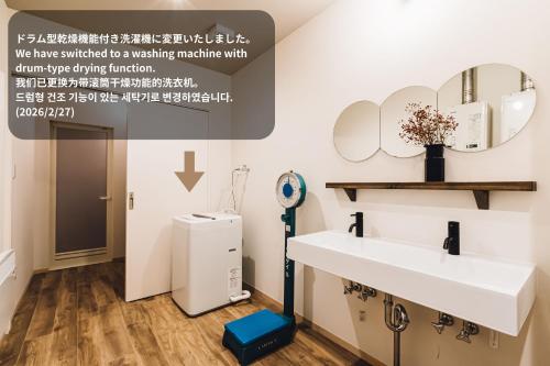 a bathroom with a sink and a mirror at Yamahana Onsen Tonden Japanese Inn in Sapporo
