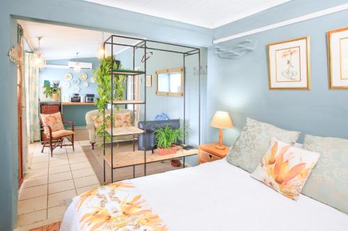 a bedroom with a bed and a living room at JoyWood Cottages in Himeville