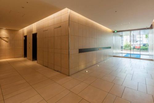 a large room with a white tile wall at Comfort Hotel Tokyo Higashi Nihombashi in Tokyo