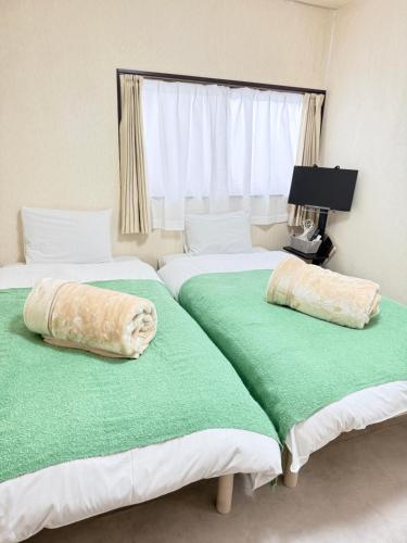 two beds sitting next to each other in a bedroom at inn 3rd in Kurashiki