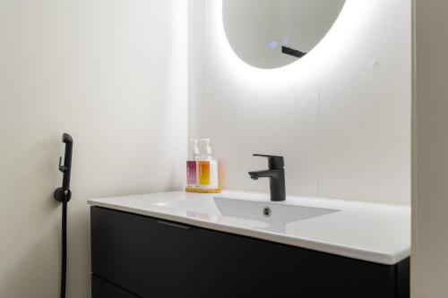 a bathroom with a sink and a mirror at Villa Taalontuuli Aurora & Forest Views sleeps 10 in Kittilä