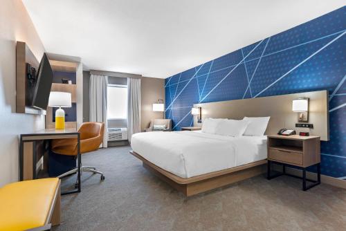 a hotel room with a large bed and a desk at Comfort Inn Pensacola near NAS Corry Station in Pensacola