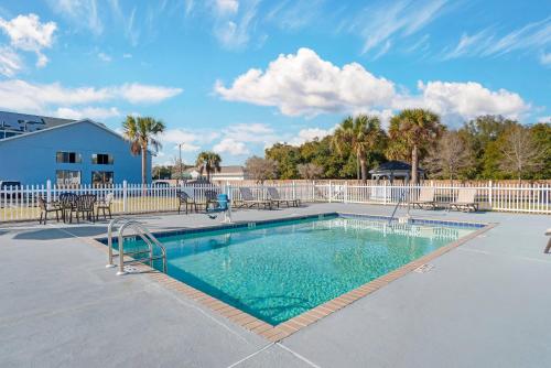 a swimming pool with chairs and a fence at Comfort Inn Pensacola near NAS Corry Station in Pensacola