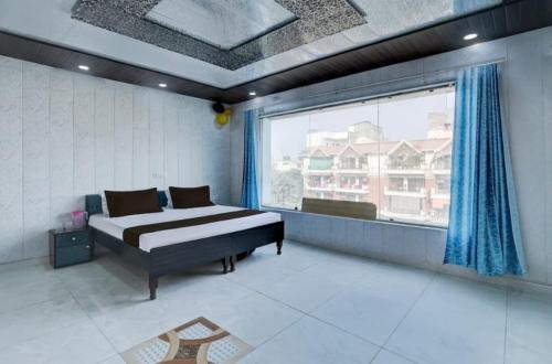 a bedroom with a bed and a large window at Nice hotel in Faridabad