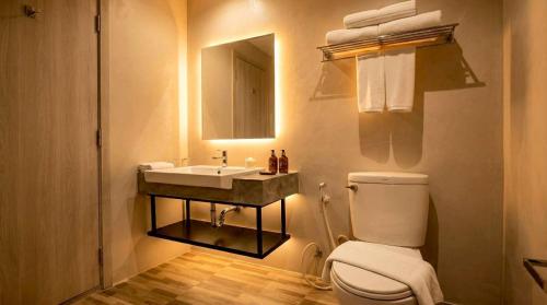 a bathroom with a toilet and a sink and a mirror at Beehive Boutique Hotel Phuket in Phuket