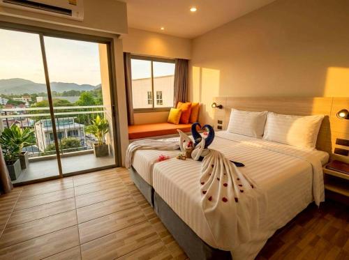 a hotel room with a bed with two dolls on it at Beehive Boutique Hotel Phuket in Phuket