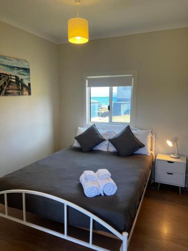 a bedroom with a bed with two towels on it at Bruny Seaview Escape in Alonnah