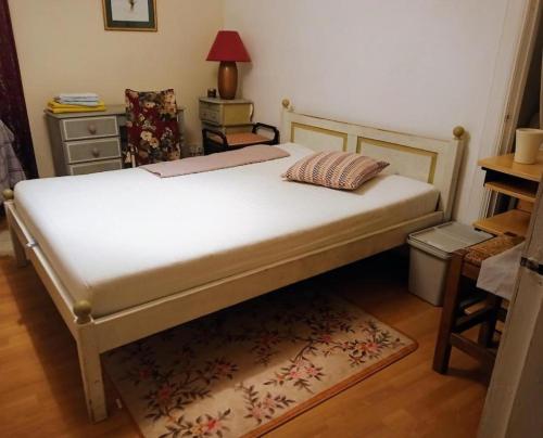 a bedroom with a bed and a table with a lamp at COSY COTTAGE FOR SHARE , Private Double Room, Wifi, Parking, Garden in Edinburgh