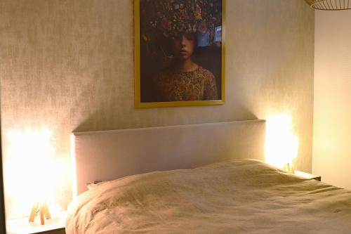 a bedroom with a bed with a painting on the wall at Huize Sonnevanck in Sexbierum
