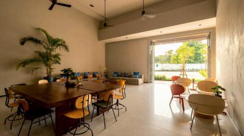 a dining room with a large wooden table and chairs at Beehive Boutique Hotel Phuket in Phuket