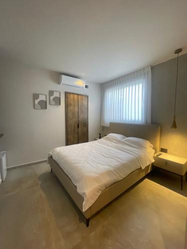 a bedroom with a large bed and a window at הוד והדר in Netanya